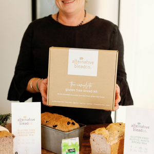 Lady holding a Gluten free bread starter kit wearing a black top 